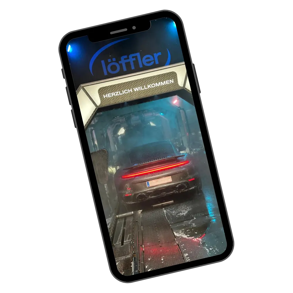 Smartphone mit Löffler App und Fahrzeug in der Waschstraße